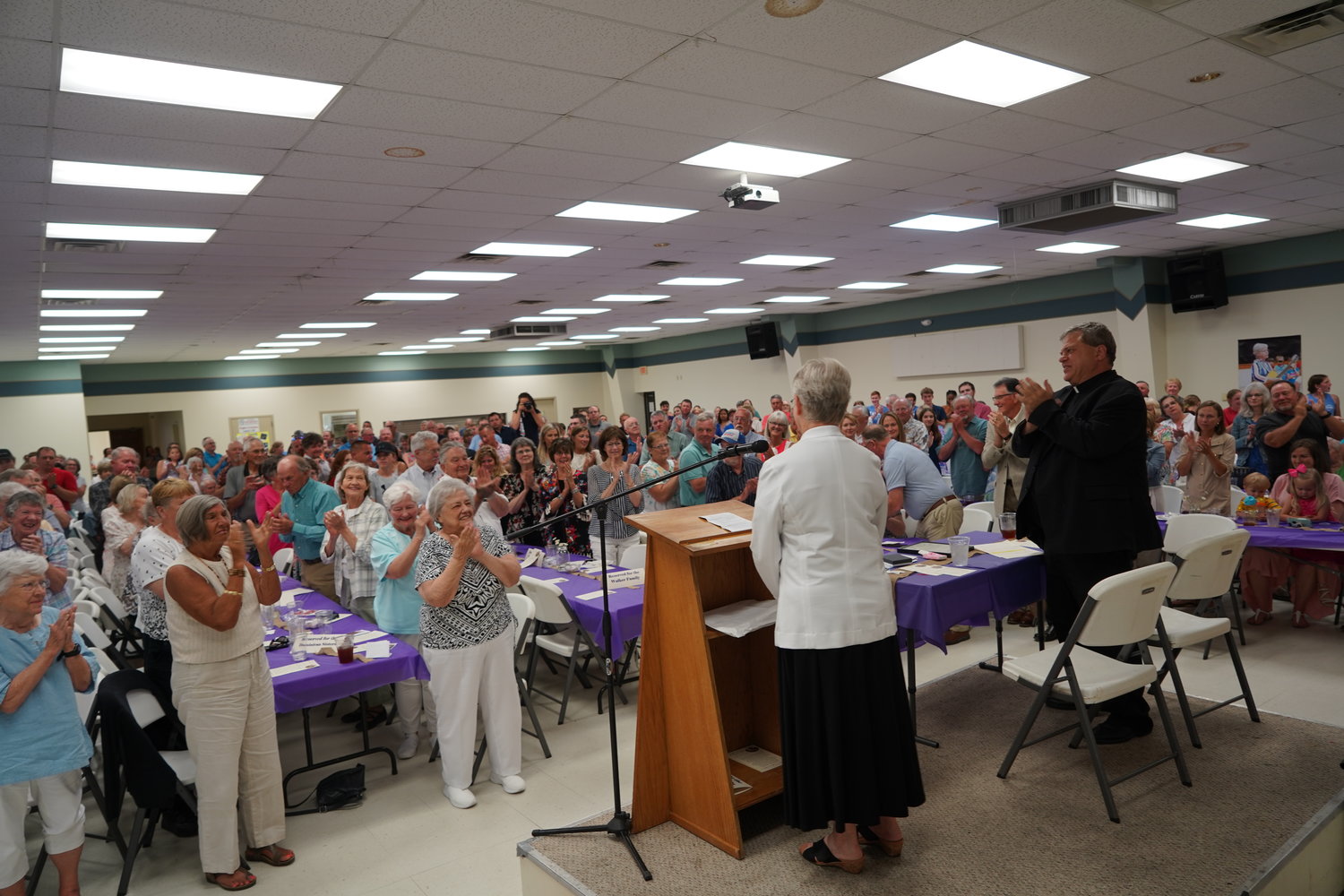 The people at a celebration of Dominican Sr. Suzanne Walker’s 38 years as principal of Holy Rosary School give her a standing ovation.